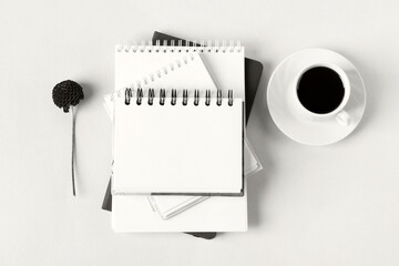 Demonstrating the colors of 2026 - Cloud Dancer. Opened blank notepad with flowers and a cup of coffee. Festive office desktop concept.