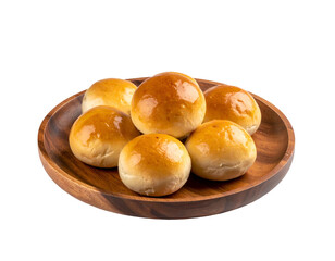 Six glossy golden baked buns on a round wooden plate, black backdrop