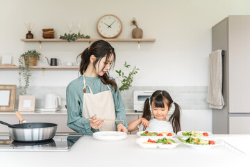 Daughter helping mom cook in the kitchen
