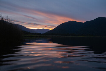 Dramatic sunset reflection on tranquil Lake Paringa, New Zealand