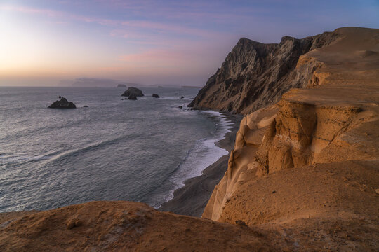 Sunset over arid cliffs and Pacific Ocean in Paracas National Reserve, Peru