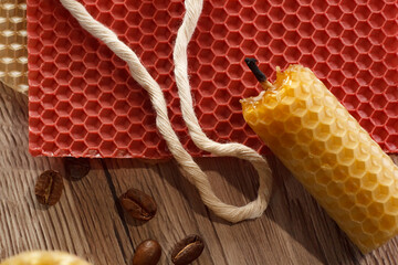 Close up of red and yellow honeycomb sheets with coffee beans on a wooden textured surface