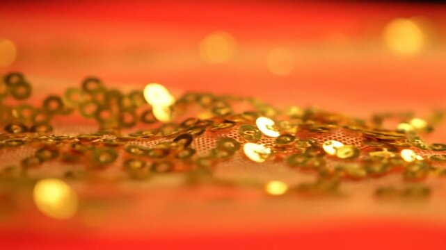 Golden Sequins Pouring on Red Fabric with Bokeh Lights for Festive Celebration, perfect for Hindu Spring Festival designs and elegant backgrounds