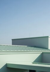 Geometric composition with blue sky and green architectural surfaces