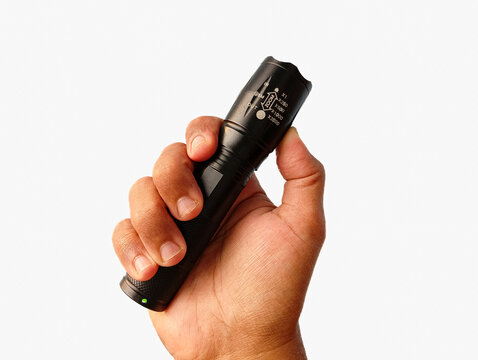 A close-up image of a hand gripping a black LED flashlight against a clean white background. Perfect for product listings, camping gear themes, and lighting equipment visuals.
