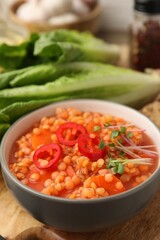 Delicious lentil soup with vegetables served on table, closeup