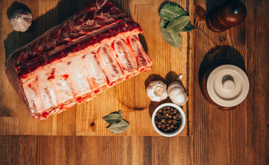 Raw pork ribs with spices on rustic table top view
