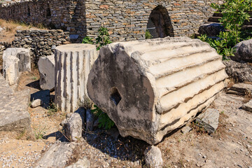 Ancient ruins with stone columns and weathered walls in sunlit archaeological site