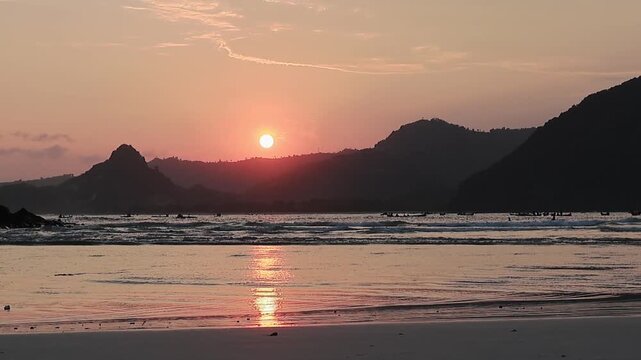 Golden Hour Sunset Seascape Over Tropical Beach with Mountain Silhouette and Reflecting Ocean Water at Lombok, Indonesia - June 22, 2025