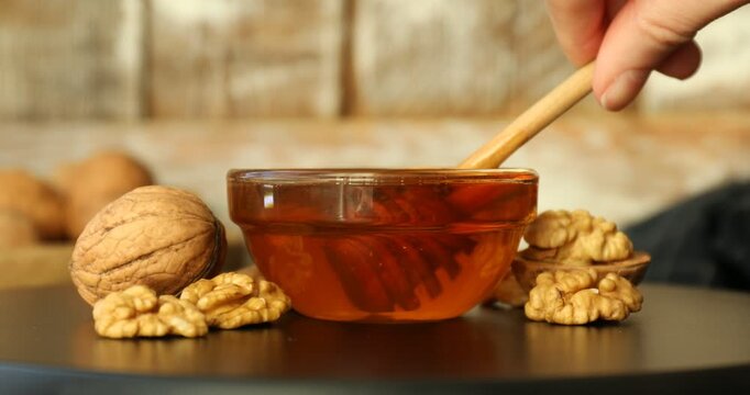 Woman with honey and nuts at table, closeup