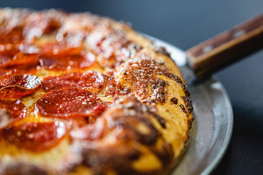 Close up of the crust on a pepperoni pizza served at a modern pizza restaurant