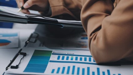 businesswoman using a calculator to calculate the numbers for financial document, finance accounting concept