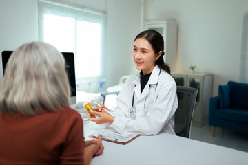 Fototapeta premium Asian doctor discussing prescription medicine with senior patient