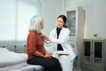 Obraz premium Female doctor examining senior patient with stethoscope