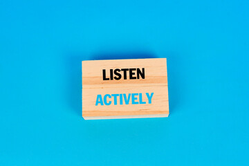 An effective communication concept presenting the phrase listen actively to symbolize attention, understanding, relationship quality and improved dialogue.
