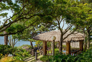 Jusangjeolli, Jeju Island, South Korea, 10.10.2015: Charming gazebo surrounded by greenery and ocean view on Jeju Island, perfect for relaxation and leisure