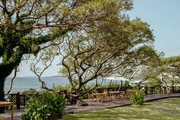 Jusangjeolli, Jeju Island, South Korea, 10.10.2015: Inviting outdoor dining area surrounded by lush greenery and ocean views on Jeju Island, perfect for gatherings