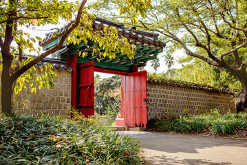 Yeomiji Botanical Garden, Traditional gate in Jeju Island, framed by lush foliage, representing the rich cultural heritage and natural beauty of Korea