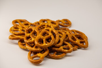 Pretzel Cookies Pile Isolated. Small Salted Pretzels, Crispy Beer Snack, German Brezel, Oktoberfest Symbol on White Background Top View