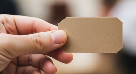 Close-up view of a hand holding a blank tag for personalized message
