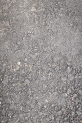 A close-up of granular asphalt showing embedded stones and bitumen, commonly used in roads and pavements for durability.