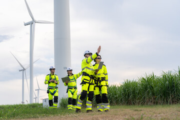 Renewable energy engineers review wind farm project plans and data to analyze the efficiency and safety of wind power generation systems.