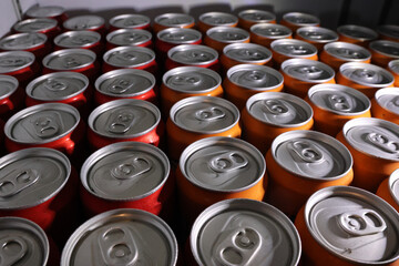 Mass production of aluminum beverage can tops at factory. An industrial background showing metal repetition on manufacturing line creating an endless pattern