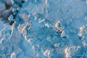 Top view of the ice. Winter aerial photograph of ice floes on the sea coast. Amazing northern nature. Frosty winter weather. Cold arctic climate. Extreme North. Natural background. Great for design.