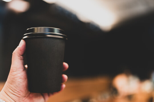 Man holding a black paper coffee cup