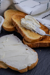 Spreading Cream Cheese on Golden Toast for a Delicious Breakfast