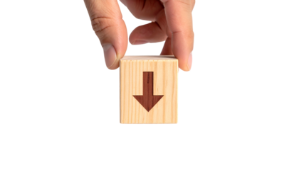 Hand holding wooden cube with downward arrow on black background