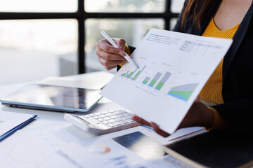 Closeup hand of Chief discuss monthly earning graph Analyzing data dashboard, business analytics, financial chart, together in the office
