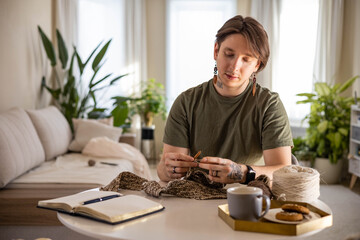 Hipster creative man crochet handmade use knitting supplies hook and wool yarn at home