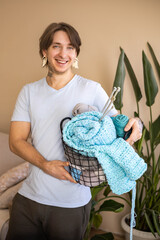 A man holds a large basket with colorful yarn.