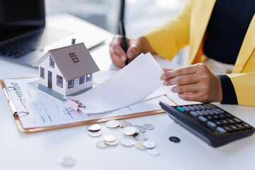 Mortgage Real Estate, woman hand using calculator to calculate home finance, accounting on bell, budget management. Doing finance, budgeting and tax calculation, monthly expenses