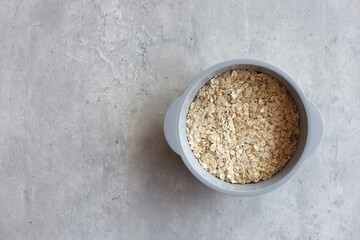 Organic oatmeal in bowl on cement floor