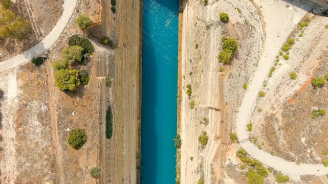Corinth Canal, Greece. The Corinth Canal is a sluiceless shipping canal in Greece, connecting the Saronic Gulf of the Aegean and the Gulf of Corinth of the Ionian Sea. Drone footage, HEAD OVER SHOT