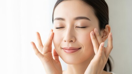 Beautiful Asian Woman Gently Massaging Her Face with Eyes Closed Smiling Light Background Pretty Young Lady Touching Her Face for Skincare and Natural Beauty