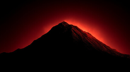 A dark mountain silhouette against a vibrant red and orange glowing background at dusk