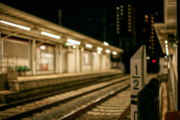 Nighttime railroad tracks and station.