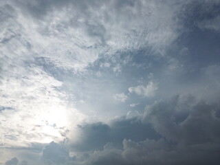 Obraz premium Sunlight hiding behind clouds creating textured cloudy sky, atmospheric nature background.