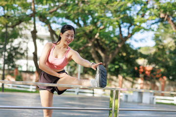 Fototapeta premium Young woman warming up leg muscles before exercise