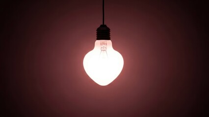 A glowing, teardrop-shaped light bulb hangs from a wire against a dark pinkish background