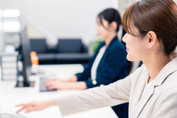 Obraz premium オフィスで事務の仕事をする若い女性社員