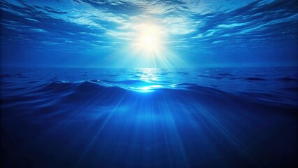 Warm sunlight breaks through the surface of a tranquil deep blue ocean
