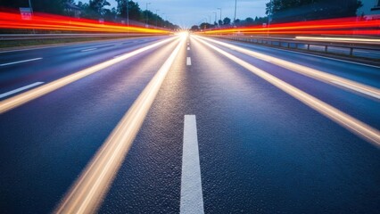 Long exposure shot of car lights streaking down a highway at dusk, leading to distant glow