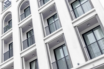 Modern white apartment building with balconies and large windows