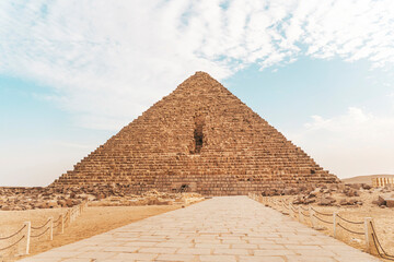great pyramid of Mikerina in Cairo, Egypt. Pyramids of Menkaura against blue cloudy sky. The entrance to the third pyramid. The road to the pyramid.