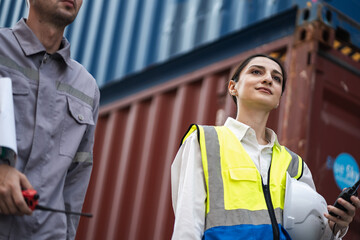 Caucasian woman logistics workers working with man worker at container site	