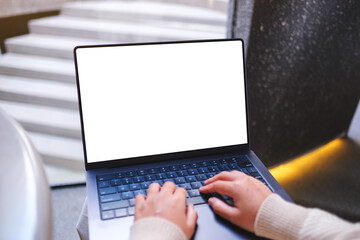 Mockup image of a woman working on laptop computer with blank white desktop screen in cafe